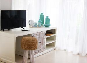 a television sitting on a desk with a chair at Harmony Villas in Kuta Lombok