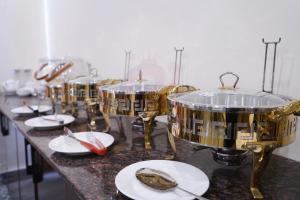 a row of drums sitting on a counter with plates at Hotel Elegant Executive Suites in Multan +21 photos