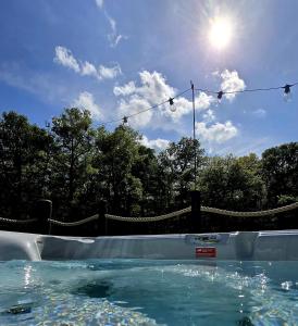 a swimming pool with the sun in the sky at Firbank Park Shepherd Huts in Dinnet