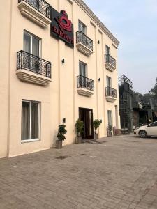 a large white building with a sign on it at Hotel Elegant Executive Suites in Multan