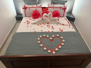 a bed with a heart made out of beads and pillows at Le manga in Chiconi
