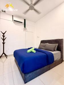 a bedroom with a bed with a blue blanket and a fan at The Single Level Bliss By Nestcove in Malacca