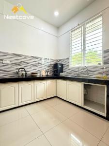 a kitchen with white cabinets and black counter tops at The Single Level Bliss By Nestcove in Malacca +11 photos