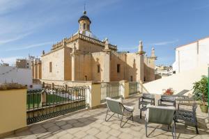 a patio with chairs and a building in the background at Luces de Catedral in Alicante