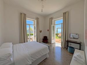 a bedroom with a bed and a tv and a window at Villa Ipomea - Terra Suite in Salerno