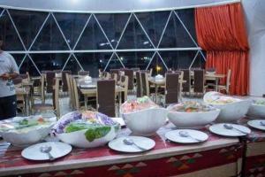 a table with bowls and plates of food on it at MAJDOLINE Desert Camp in Wadi Rum