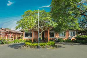 a house with a tree in front of it at The International Centre Goa in Panaji