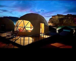 a dome shaped building with a sunset in the background at MAJDOLINE Desert Camp in Wadi Rum