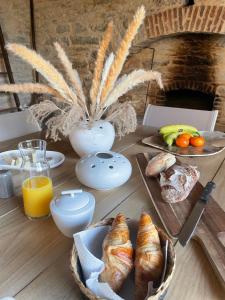 a table with pastries and orange juice and bread on it at Mas de Méjas Chambre d'hôtes La Pierraille in Calvignac
