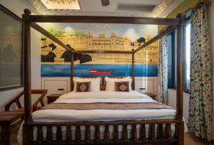 a bedroom with a canopy bed with a painting on the wall at UDAISA - The Luxury Art in Udaipur +57 photos