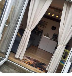 a view of a living room through a window with curtains at Vinnies hideaway in Morpeth