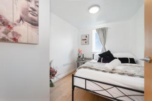 a bedroom with a bed and a window at Stylish 2-Bed Manning Gardens in South Norwood