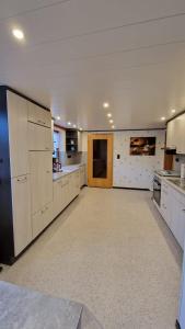 a large kitchen with white cabinets and a large room at Ferienwohnung Altrichter in Wabern