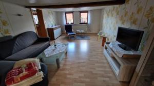 a living room with a couch and a flat screen tv at Ferienwohnung Altrichter in Wabern