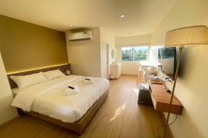 a bedroom with a large bed and a lamp at Shade House - Phuket Downtown in Phuket