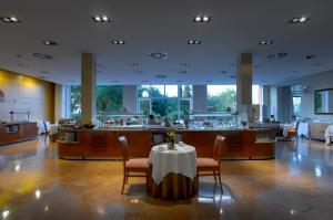 Un restaurante con una mesa y sillas y un bar. en Parador de Cordoba, en Córdoba