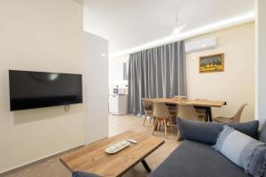 a living room with a couch and a table at Sinani Apartment - Sea View Balcony & Jacuzzi Gem in Asgourou