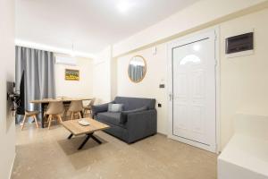 a living room with a blue couch and a table at Sinani Apartment - Sea View Balcony & Jacuzzi Gem in Asgourou