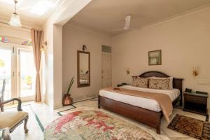 a bedroom with a large bed and a mirror at Barwara Kothi in Jaipur