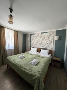a bedroom with a bed with two towels on it at Hotel Nestt in Kazbegi