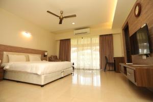 a bedroom with a bed and a ceiling fan at The International Centre Goa in Panaji
