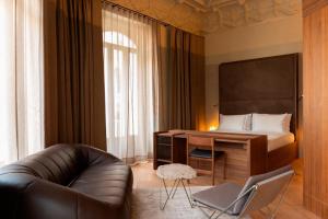 a room with a couch and a desk and a bed at Mercer Madrid in Madrid