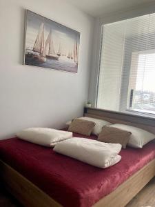 a bed with four pillows on it in a room at Apartment Poprad in Poprad