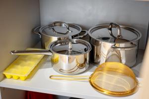 three pots and pans sitting on a kitchen counter at Sunny Hill in Palanga