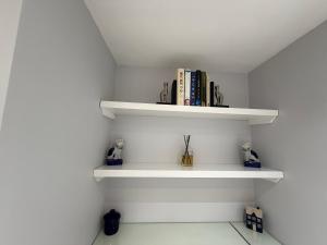 a room with white shelves with books at Central Stow Bakehouse Flat in Stow on the Wold