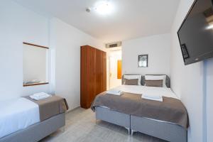 a bedroom with two beds and a flat screen tv at Hotel Podostrog - New Comfort 2026 in Budva +35 photos