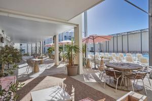 a patio with a table and chairs on a building at Hôtel Nakara by Odalys in Cap d'Agde