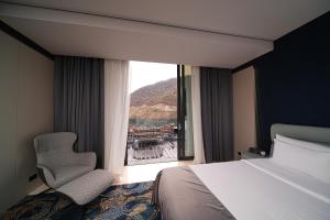 ein Schlafzimmer mit einem Bett, einem Stuhl und einem Fenster in der Unterkunft Mounthree in Pʼambak