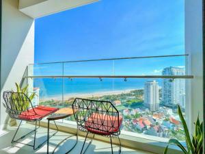 a balcony with a table and chairs and a large window at Ngân Nguyễn Apartment - The Sóng Vũng Tàu in Vung Tau