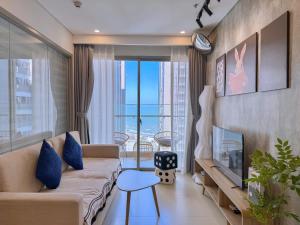 a living room with a couch and a large window at Ngân Nguyễn Apartment - The Sóng Vũng Tàu in Vung Tau