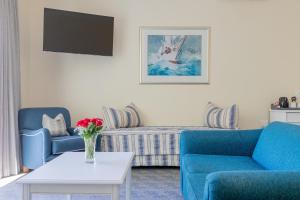 ein Wohnzimmer mit zwei blauen Sesseln und einem Tisch in der Unterkunft The Beach Hotel in Port Elizabeth