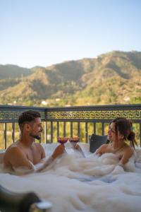 a man and a woman sitting in a hot tub at Perfectstayz Premium Aurevva, Rajpur road in Rājpur