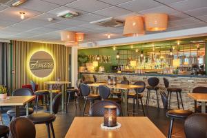 a restaurant with tables and chairs and a bar at Résidence Odalys Nakâra in Cap d'Agde