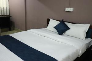 a bed with blue and white pillows in a room at Hotel Golden Mahseer in Tezu