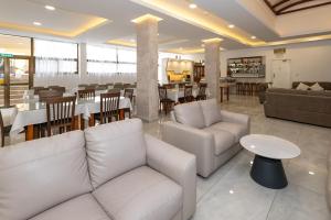 a restaurant with white couches and a table and chairs at Mariela Hotel Apartments in Polis Chrysochous