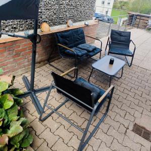 two chairs and a table and an umbrella on a patio at Ferienwohnung Kampić Turmblick in Rottweil
