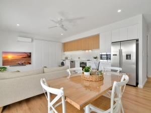a kitchen and living room with a table and a couch at Lillian Waters Retreat in Yamba