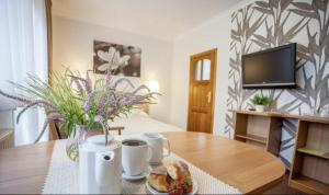 a living room with a table with a vase of flowers at Villa Anna - Noclegi Rooms - FREE parking, taras, 1500m do Starówki in Gdańsk