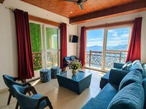 a living room with a blue couch and a large window at Opal Villas Mussoorie near Mall Road in Mussoorie
