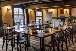 a row of tables and chairs in a room with windows at The Thatch Inn in Gloucester