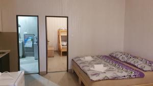 a small bedroom with a bed and a mirror at Apartmány Puerto in Senec