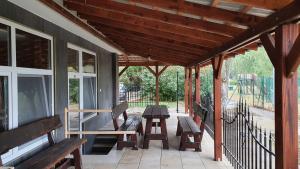 a covered porch with benches and a picnic table at Apartmány Puerto in Senec