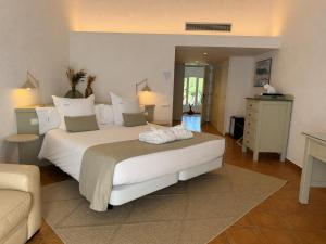 a bedroom with a large white bed and a couch at Hotel Calina in Cadaqués