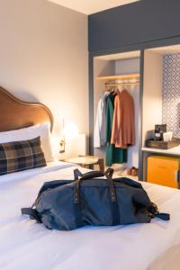 a blue bag sitting on top of a bed at The Hoya Hotel at Georgetown in Washington, D.C.