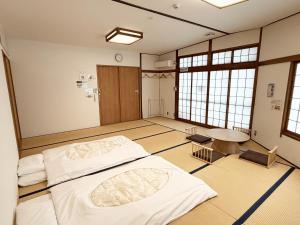 a room with two beds and a table in it at 4S STAY Awaikeda Ekimae in Miyoshi