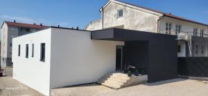 a white and black house with a black entrance at Sobe i Apartman Nada Ljubuški Soba 1 in Ljubuški